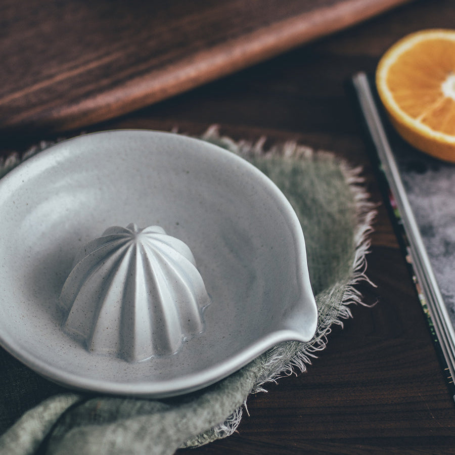 Juice d'agrumes dans un bol presse-agrumes RENFAN blanc en céramique, prêt à extraire le jus.