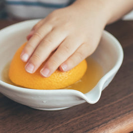 Juice d'agrumes dans un bol presse-agrumes RENFAN, outil en métal pour extraire le jus des fruits.