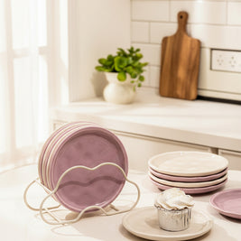 Assiettes Northfolk Renfan en céramique avec motif floral coloré, présentées empilées sur une table en bois.