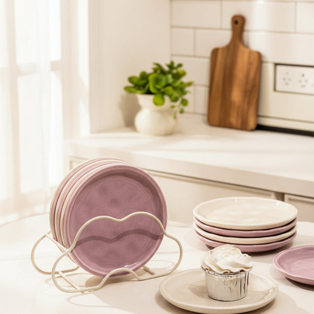 Assiettes Northfolk Renfan en céramique avec motif floral coloré, présentées empilées sur une table en bois.