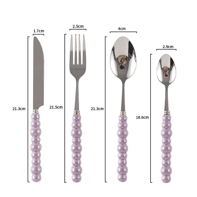 Couverts VidaXL Athenes, ensemble de fourchette, couteau et cuillère en acier inoxydable, disposés sur une table en bois.