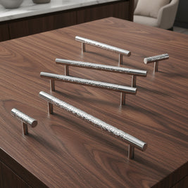 Poignées et boutons Faria en chrome, design moderne, visibles sur une surface claire, pour meubles ou décoration intérieure.