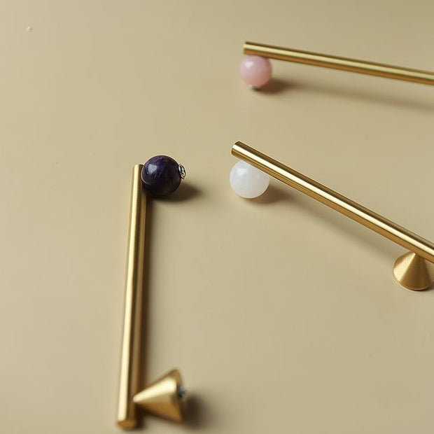 Poignées et boutons de porte d'armoire Deauville de la marque Renfan, en métal avec finition élégante, visibles sur l'image.
