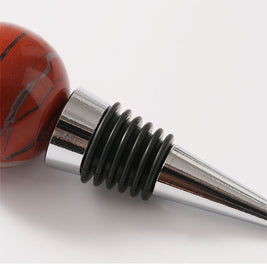 Bouchon de bouteille de vin en pierre brute naturelle Emilion, produit par Renfan, posé sur une surface en bois.